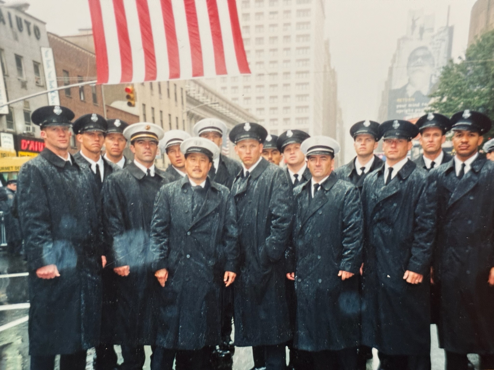 Mel and his Hayward Fire crew in dress coats on a rainy New York street